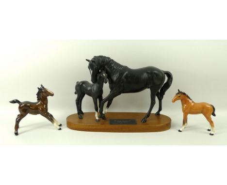 A Beswick figure of Black Beauty and foal, on a wooden base, 21cm, a gloss brown foal, and a light tan horse, 12cm. (3)