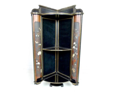 A Japanese shubayma corner cabinet, circa 1890, the ebonised frame with gold highlights, three quarter round shelves flanked 