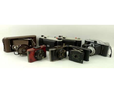 A collection of cameras comprising a Canadian vest pocket folding camera with ball bearing shutter patented 1910 in carrying 