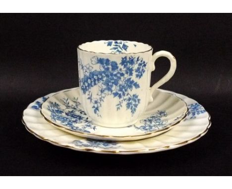 A part tea service, mid 19th century, with scallop fluted cups and plates, decorated with blue flowers and foliage with gilt 