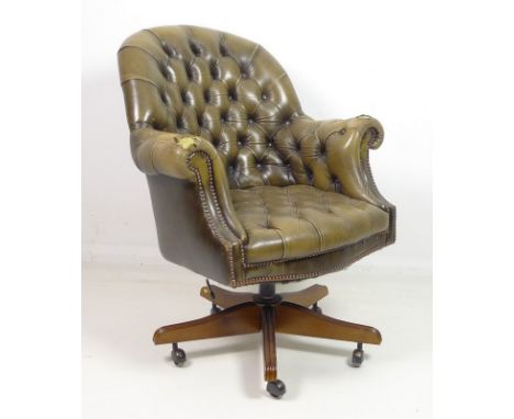 A leather button back Chesterfield style tub office chair, circa 1970, with swivel action on outswept five footed base with c