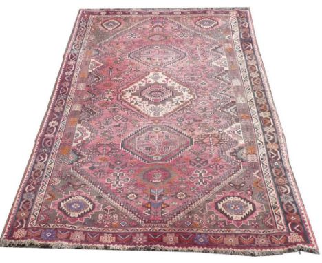 A Hamadan Afshar rug, circa 1920, with three diamond medallions and botehs to the corners, and rug filler elements on a light