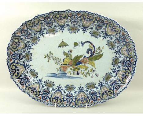 A Dutch Delftware polychrome server, 18th century, with a central decoration depicting a seated female amongst foliage, surro