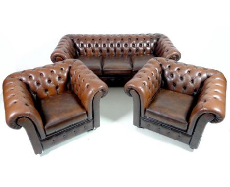 A brown leather Chesterfield type three seater sofa, late 20th century, 200 by 85 by 69cm high, together with two matching ar