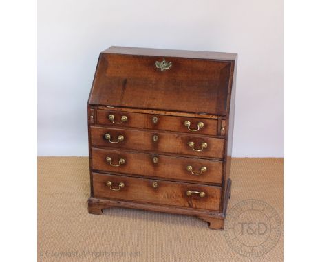A George III oak bureau, with fall enclosing a fitted interior, above four graduated long drawers, on bracket feet, 108cm H x