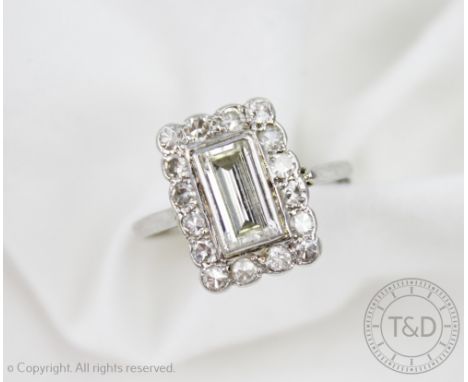 An Art Deco diamond rectangular cluster ring, designed as a central baguette cut diamond, within a surround of sixteen eight-