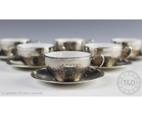 A set of six continental silver teacups and saucers, circa 1910, each with bright cut decoration and vacant oval cartouche, t