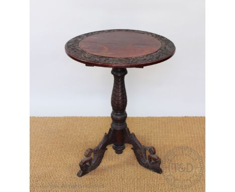 A late 19th century Anglo Indian carved and stained soft wood table, with circular top on turned and carved column and figura