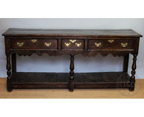 An 18th century type oak dresser, with an arrangement of three drawers, above a pot shelf, on turned legs and block feet, 92c