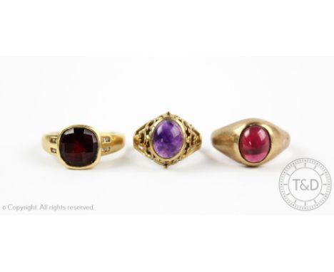 A cabochon garnet set 9ct gold signet ring, a cabochon smethyst set gold ring, and a faceted garnet and diamond set dress rin