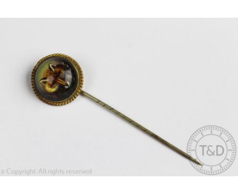 A Victorian reverse painted foxes mask stick pin, within rope twist surround, unmarked, 7.5cm long overall