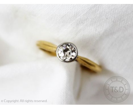 A diamond solitaire ring, the old brilliant cut diamond, collet set in white metal, to the tapering yellow gold shoulders and