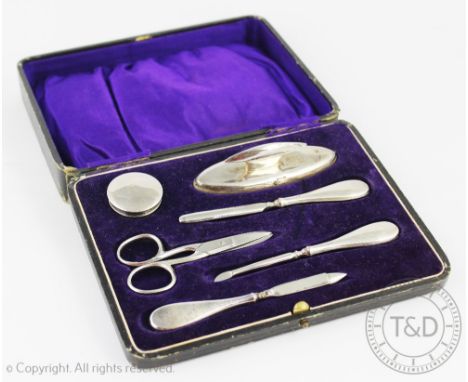 A cased George V silver manicure set, the case with silk and velvet lining enclosing an arranged interior including a nail bu