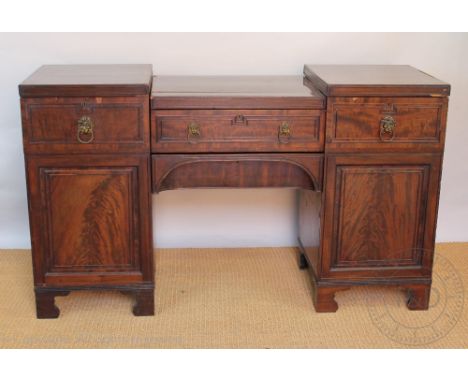 An early 19th century mahogany pedestal sideboard, with an arrangement of four drawers and two cupboard doors on bracket feet