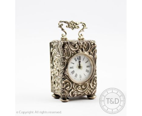 A Victorian silver cased miniature time piece, London 1897, the case with profusely embossed scrolling flowers and foliage an