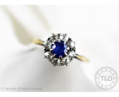 An untested sapphire and diamond circular cluster ring, the central sapphire within an eight stone diamond surround, all set 