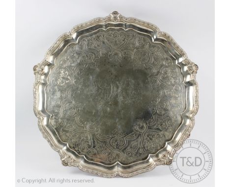 A large Victorian silver salver, R & S Garrard & Co, London 1859, of circular form and upon three scroll feet, the cast rim e