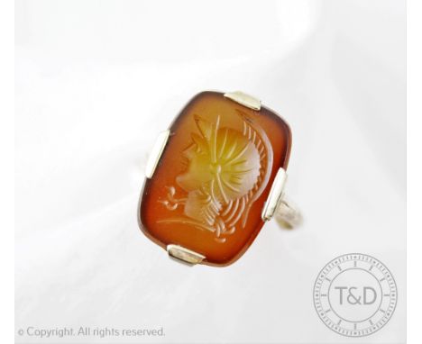 An intaglio set ring, carved with a profile portrait of a Roman type warrior in battle dress, within four claw setting, stamp