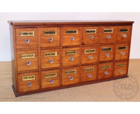 A vintage apothecary bank of drawers, eighteen drawers with gilt backed glass name plates and glass handles, 55cm H x 110cm W