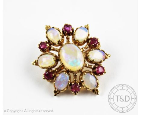 An opal and ruby set 9ct yellow gold brooch/pendant, London 1984, designed as a central opal within a surround of alternating