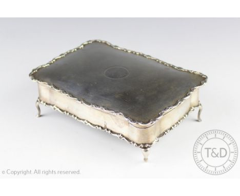 A George V silver jewellery casket, Sir John Bennett Ltd, Birmingham 1912, the rectangular casket with rocaille border and va