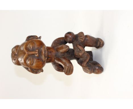 An African fetish - early - featuring a breast feeding mother with her child who has had a skull craniotomy - to let out evil