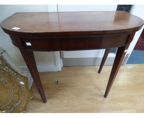 A George III mahogany fold over card table, the top inlaid and cross banded in rosewood, raised on square tapering legs 