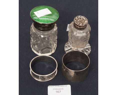 A cut glass dressing table bottle with green engine turned enamelling top, a cut glass pepperette with silver top, two silver