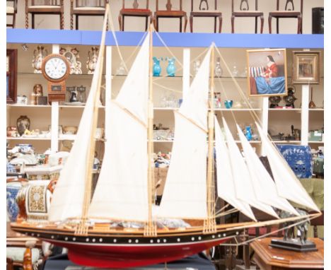 A model four casting sailing vessel, wooden deck and red hull, mounted on black rectangular base 