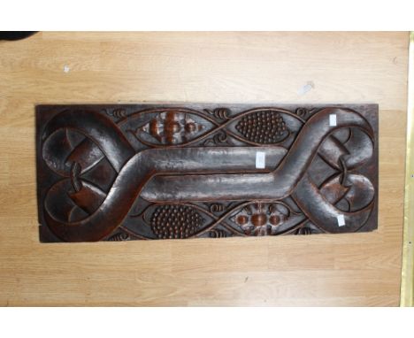 An early 17th century oak wall panel carved with intertwined vines and ribbons, 80cm x 31cm
