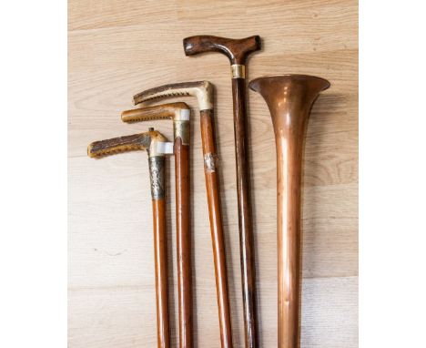 Three horn handled crops, one with silver collar, one 'whipper-in' crop, a copper hunting horn, and a walking stick (5)