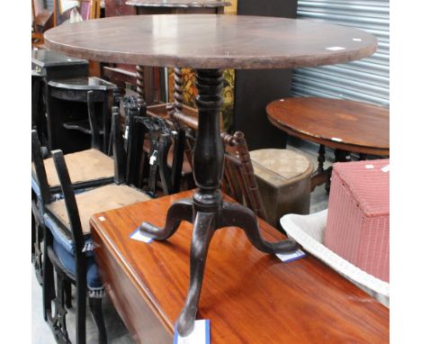 A George III mahogany tilt top tripod table, the circular top raised on a turned column 