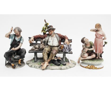 A collection of Capo di Monte comprising man sitting on bench a figure group of a young couple with a dog and a cobbler (3) 