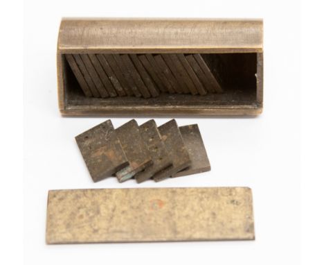 An early 20th Century miniature brass cased set of domino, case shaped like part of a gun barrel 