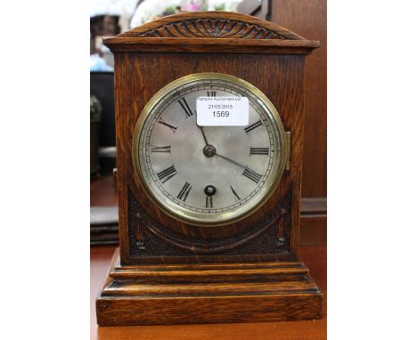An early 20th Century oak eight day mantle clock, with a silvered dial and black Roman numerals, the sial with a single Winds