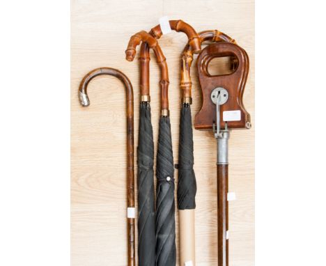 A late Victorian white metal mounted bamboo walking cane; together with three umbrellas and a Yeoman shooting stick (5) 