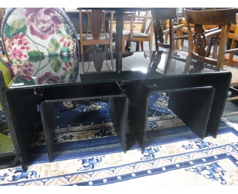 A contemporary black glass coffee table, fitted two lamp tables beneath 