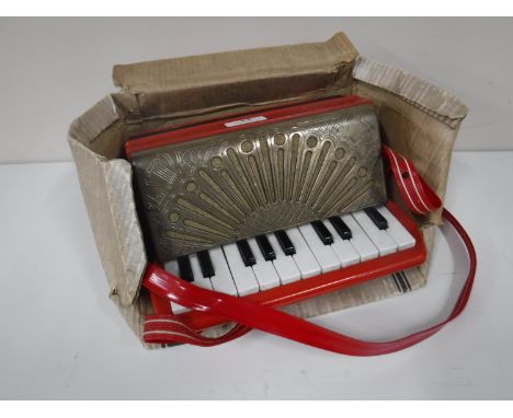 A Goldentone child's size accordion, in the original packaging with music