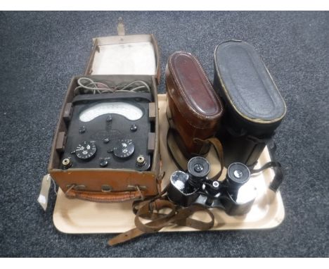 A tray of leather cased Bakelite Avo meter, two sets of vintage binoculars 