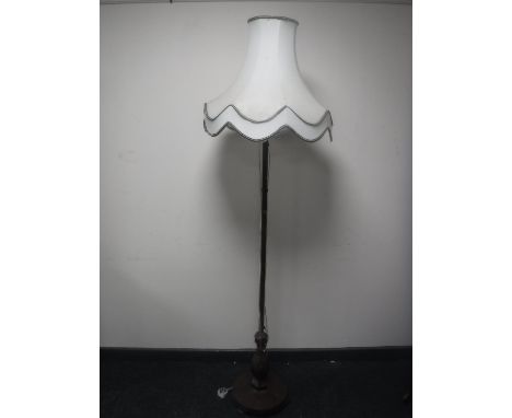 An antique rosewood standard lamp with shade