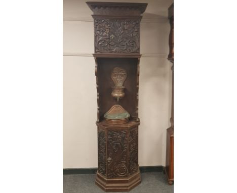 A 19th century continental heavily carved oak washstand fitted two cupboards, with central copper basin, height 214cm
