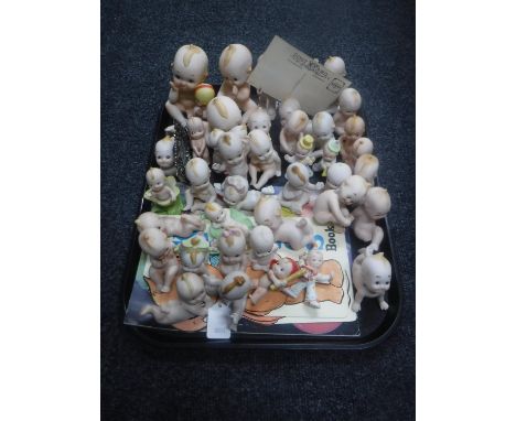 A tray of 20th century porcelain Kewpie Babies, two plastic dolls and books 