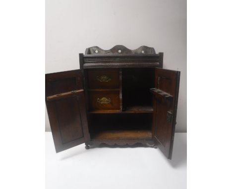 A Victorian oak double door smoker's cabinet with carved panel doors CONDITION REPORT: 46cm high by 33cm wide by 17cm deep. 