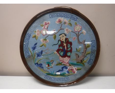A circular mahogany framed oriental needlework panel