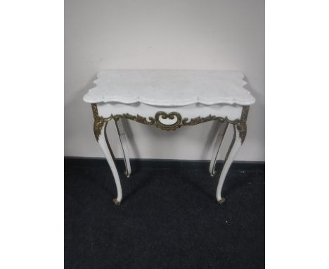 A white and gilt marble topped console table 