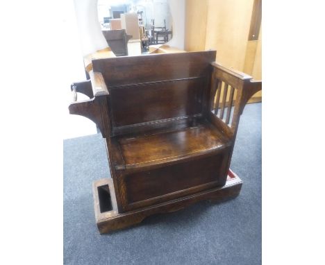 An Edwardian oak storage hall seat with stick stands 