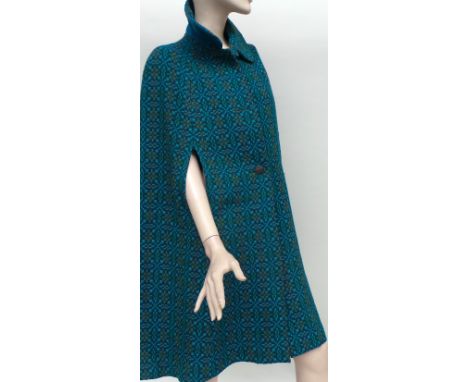 A Welsh wool cape in blues and greens and a 1970s red, soft leather double-breasted and fitted coat. The cape has two buttons