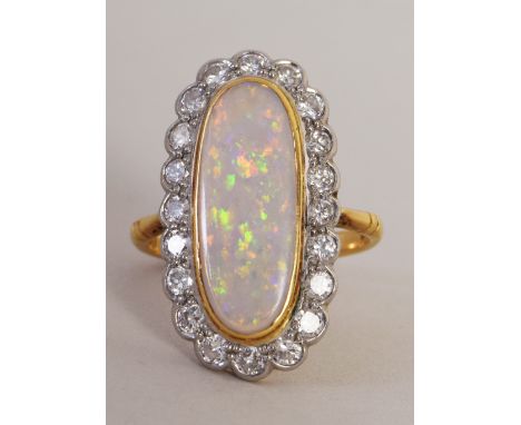 A ladies 18ct gold and white opal dress ring, the oval cabochon surrounded by small cut diamonds Size N