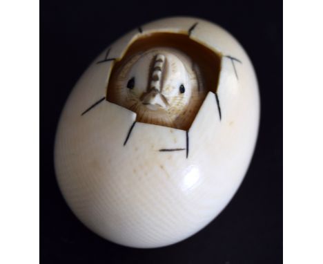 A Japanese netsuke of a chick emerging from an egg from the Meiji period, charcters to the base