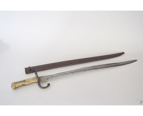 A French chassepot bayonet in scabbard from the Second French Empire featuring worn engraving on the ricasso, 69.5cmL